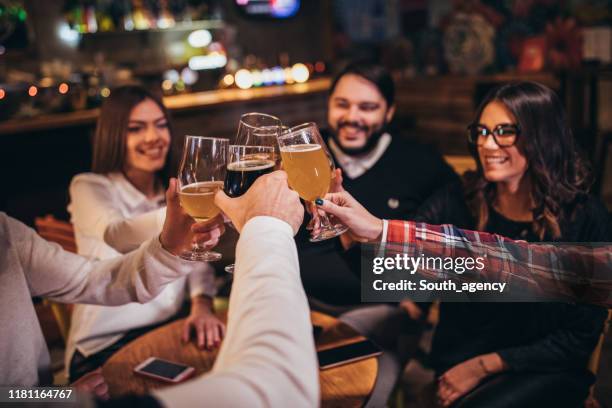 amigos tomando un brindis en el bar - cerveza artesanal fotografías e imágenes de stock