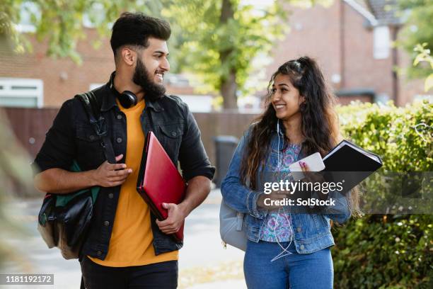 teenage siblings walking down street - pakistanischer abstammung stock-fotos und bilder