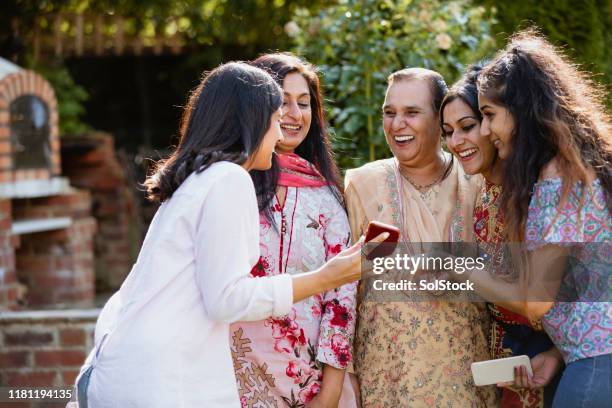 family time in the garden with mobile phone - pakistani culture stock pictures, royalty-free photos & images