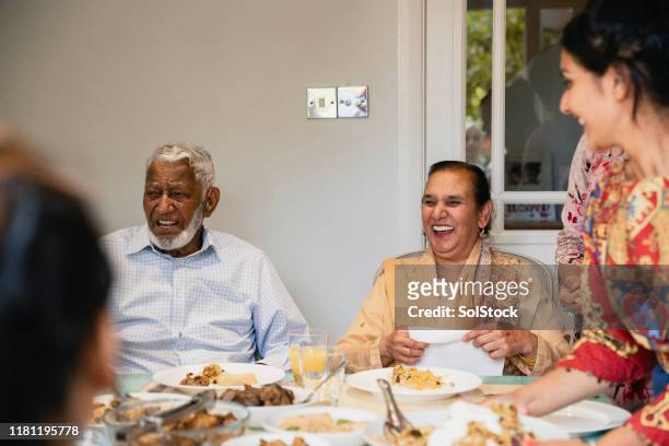 dinner and laughing - indian family dinner table stock pictures, royalty-free photos & images