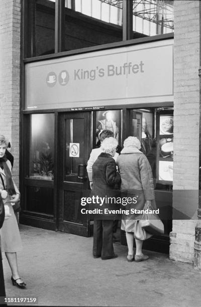 Three women inspect the menu outside the King's Buffet, railway station buffet restaurant, London, 4th December 1980.