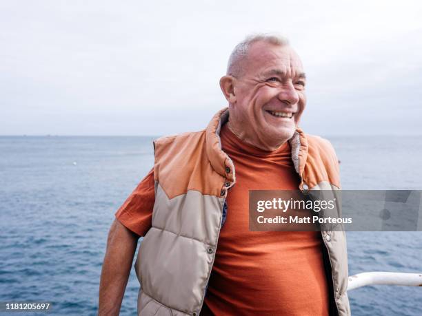 seaside portrait of old man - beach lifestyle stock-fotos und bilder