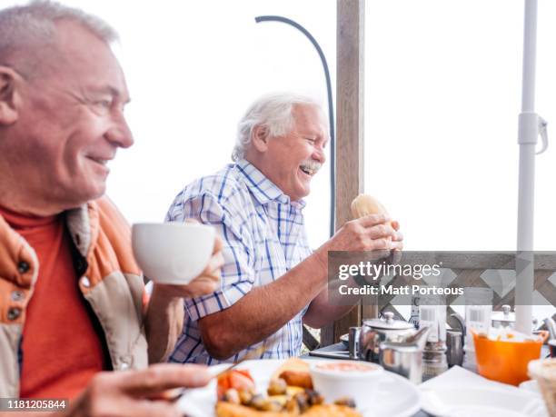 friends laughing at breakfast - channel islands england stock pictures, royalty-free photos & images