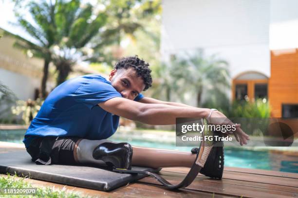 portret van de jonge man met prothetische been stretching in de werf - latina legs stockfoto's en -beelden