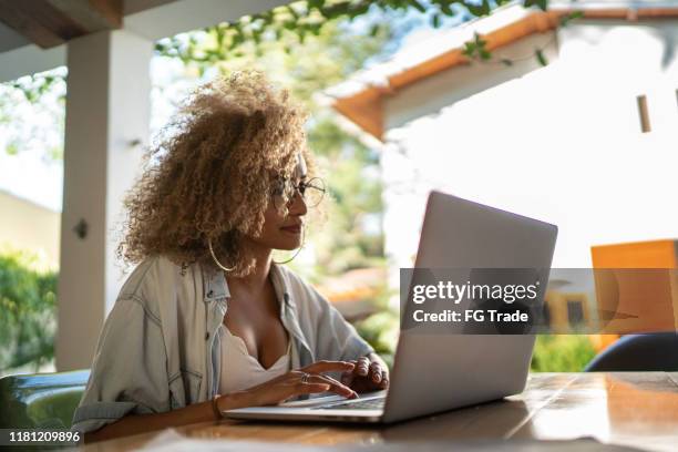 mid adult woman using laptop at home - testimonial stock pictures, royalty-free photos & images