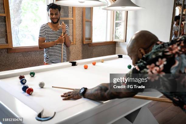 cousins / friends playing snooker during a family reunion - family snooker stock pictures, royalty-free photos & images