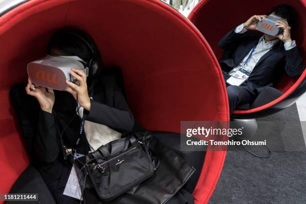 Attendees wear VR headsets as they try 5G network technologies in the KDDI Corp.'s au brand booth during the Ceatec Japan 2019 consumer electronics...