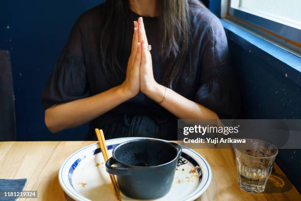 a woman finishes her lunch - 祈る 手 ストックフォトと画像