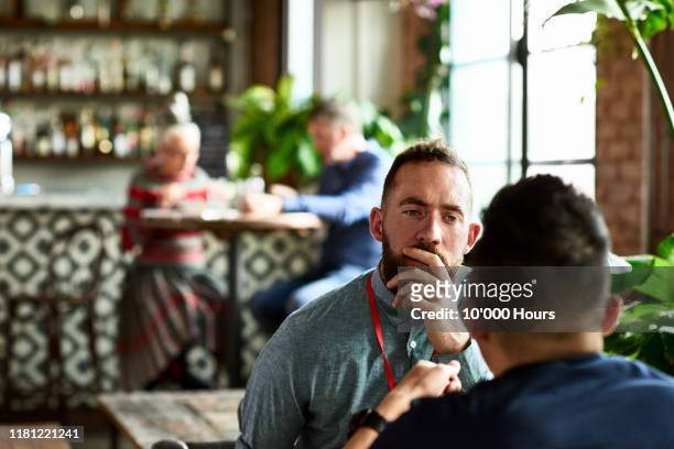 man listening thoughtfully to business colleague in restaurant - emotional support 個照片及圖片檔