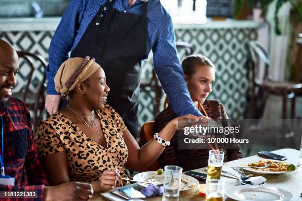 independent woman paying waiter on contactless card machine - business meal stock pictures, royalty-free photos & images