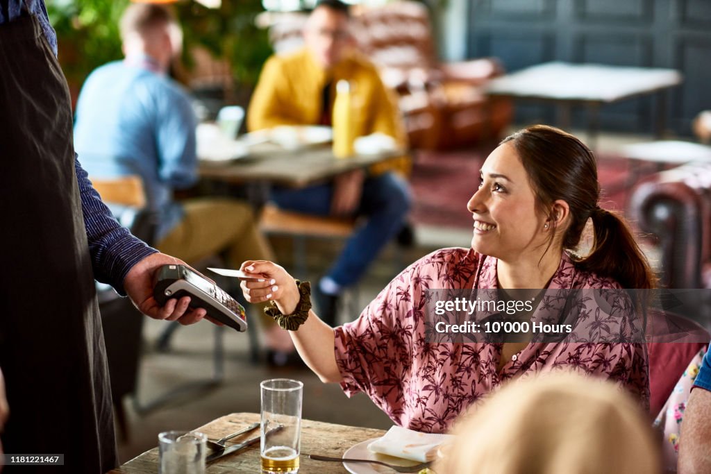 Attractive woman using contactless technology in cafe