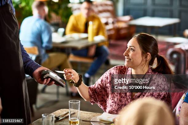 attractive woman using contactless technology in cafe - paying stock pictures, royalty-free photos & images