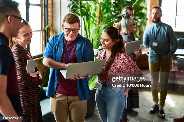 trainees looking at laptop in office break out space - emotional connection stock pictures, royalty-free photos & images