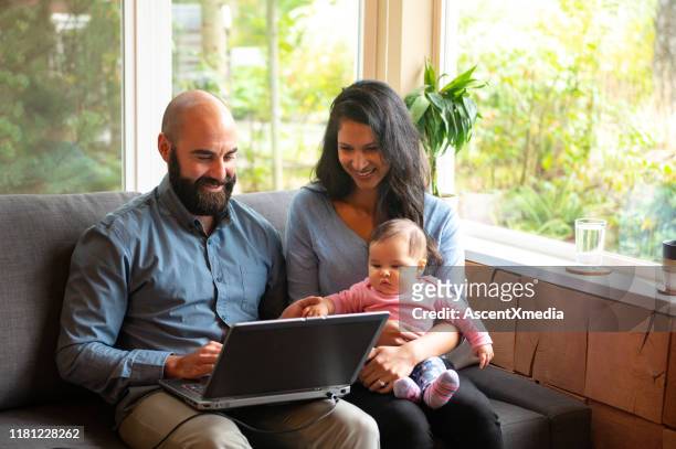 couple going over home finances with a newborn - two parents stock pictures, royalty-free photos & images