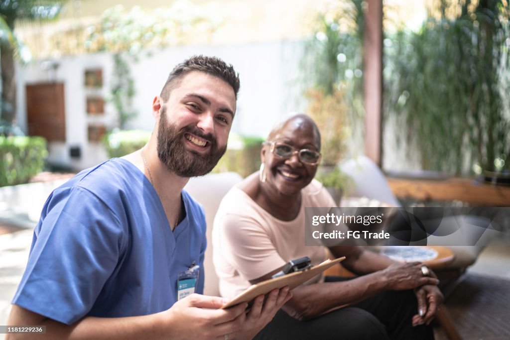 Smiling Home Portrait Of Smiling Home Caregiver And Senior Woman High-Res Stock ...