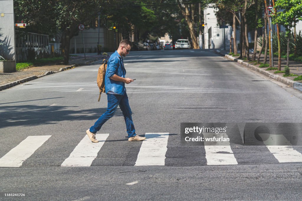 Jonge man lopen op zebrapad op de straat van een Sao Paulo