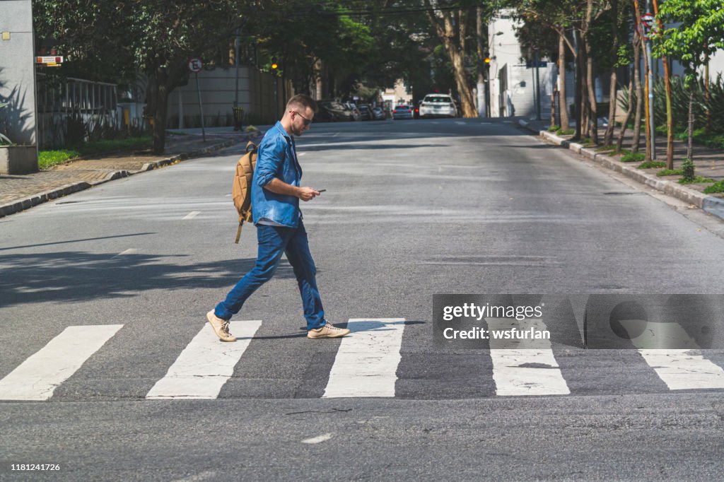 Young man walking at crosswalk on a Sao Paulo's street