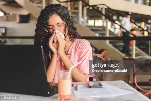 young woman blowing her nose - sinusitis stock pictures, royalty-free photos & images