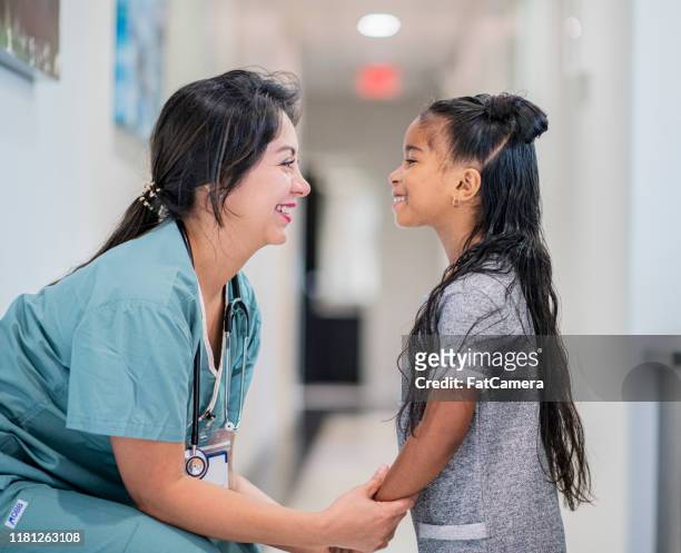 doctor talking to a little girl stock photo - childhood cancer stock pictures, royalty-free photos & images