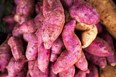 Fresh purple coloured Sweet Potatoes stack in a local market.