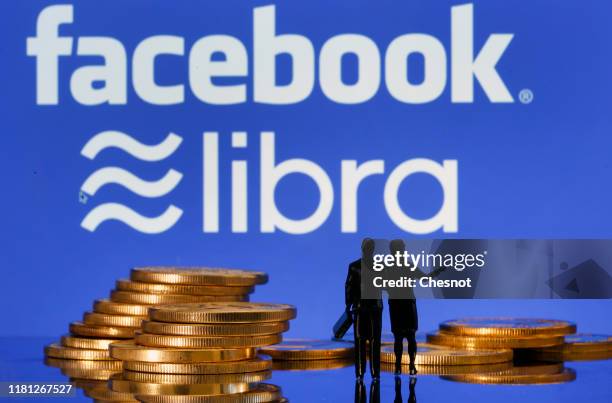 In this photo illustration, a visual representation of digital cryptocurrency coins sit on display in front of Libra and Facebook logos on October...