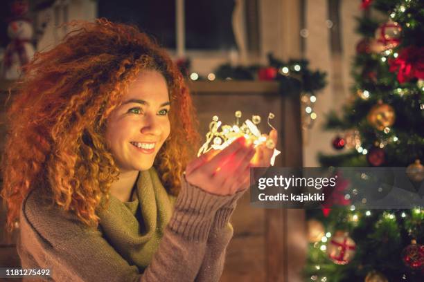 光沢のあるクリスマスライトを保持する美しい女の子 - 不思議グッズ ストックフォトと画像