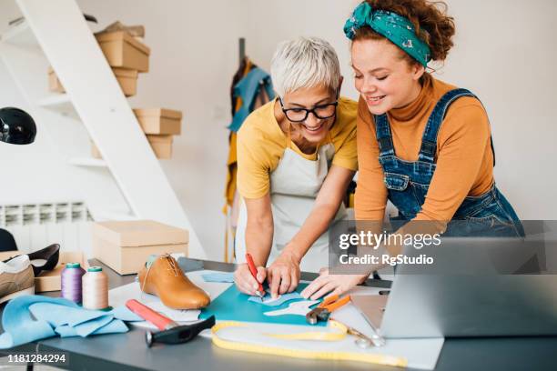 young shoemaker learning to work from the older colleague - shoe factory stock pictures, royalty-free photos & images