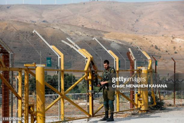 An Israeli soldier closes a border gate on the Israeli side of the border at the Jordan Valley site of Naharayim, also known as Baqura in Jordan,...