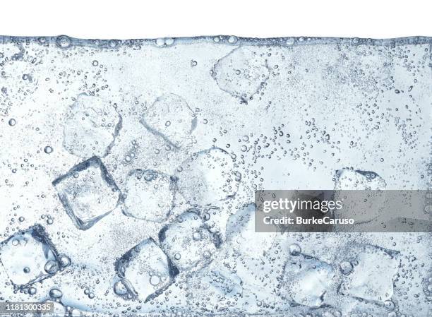 ice cubes floating in water - dr pepper stockfoto's en -beelden