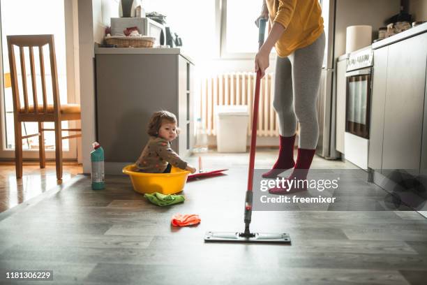 giovane madre con una bambina che fa i lavori domestici - lavori di casa foto e immagini stock