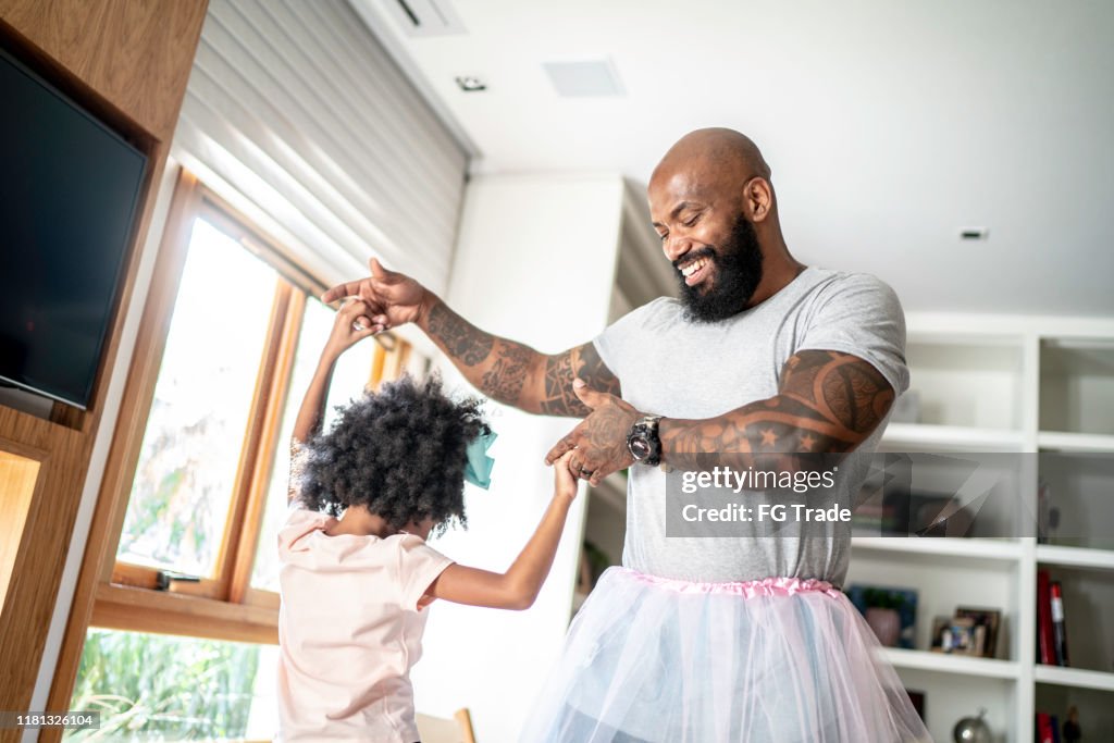 Père drôle avec des jupes de tutu dansant comme des ballerines
