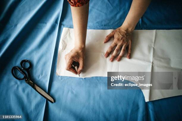 tailor using chalk to mark the pattern - sewing pattern stock pictures, royalty-free photos & images