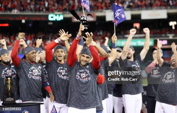 Manager Dave Martinez of the Washington Nationals celebrates with the trophy after winning game four and the National League Championship Series...