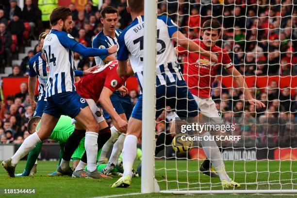 Manchester United's English midfielder Scott McTominay and Manchester United's English defender Harry Maguire scramble for the ball as it goes past...