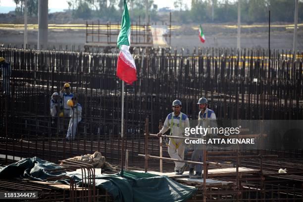 Picture taken on November 10 shows workers on a construction site in Iran's Bushehr nuclear power plant during an official ceremony to kick-start...