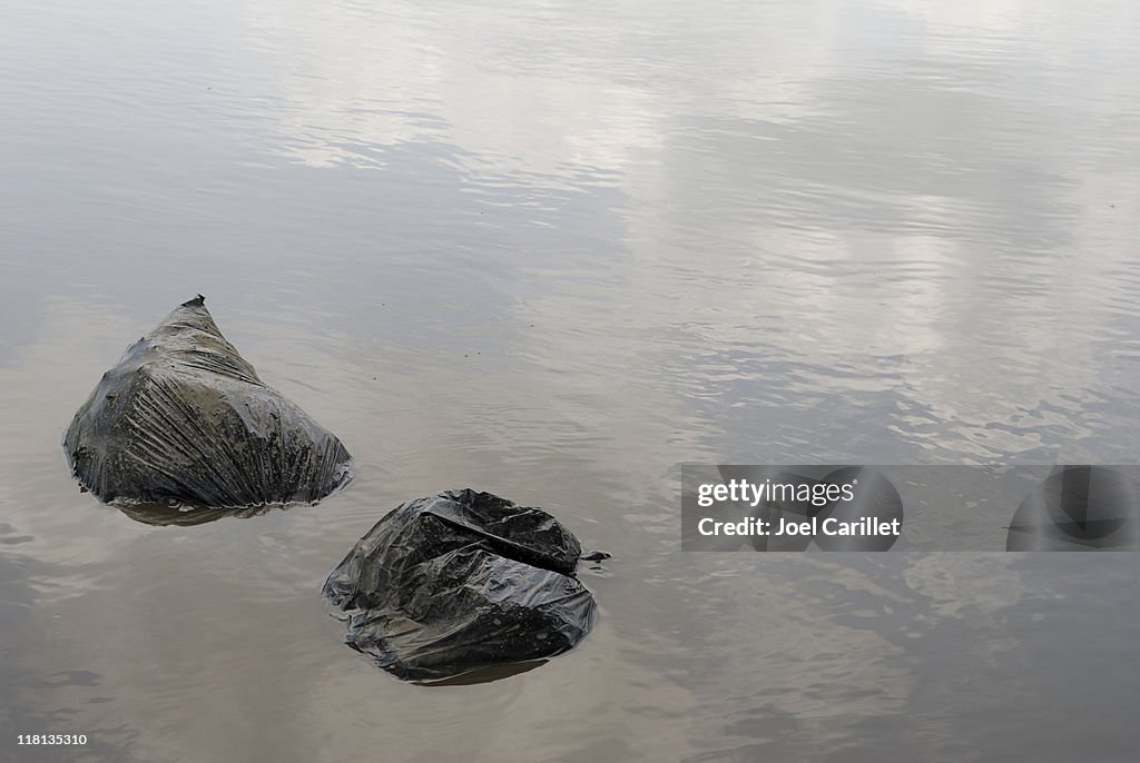 Bolsas de basura de plástico vierten en agua