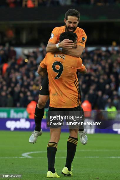 Wolverhampton Wanderers' Mexican striker Raul Jimenez celebrates with Wolverhampton Wanderers' Portuguese midfielder Joao Moutinho after scoring...
