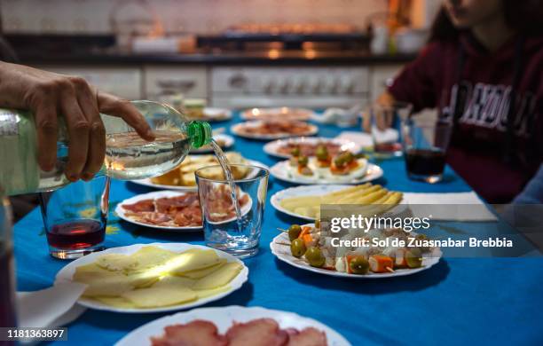 close-up of a hand pouring water in a glass on the family table - kin in de hand stock-fotos und bilder