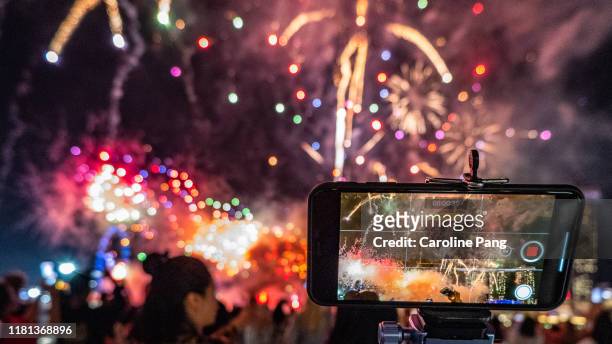 mobile phone recording 4k video of stunning fireworks. - iphone outline imagens e fotografias de stock