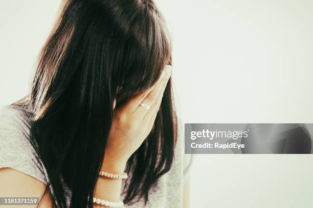 face obscured by her hair, young woman weeps - crying portrait stock pictures, royalty-free photos & images