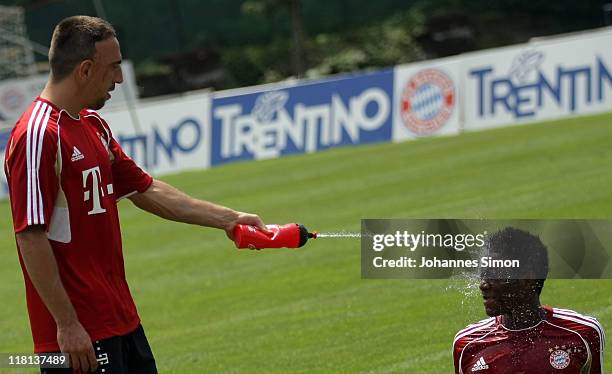 Franck Ribery of FC Bayern Muenchen refreshes team mate David Alaba with water during a training session on July 4, 2011 in Riva del Garda, Italy.