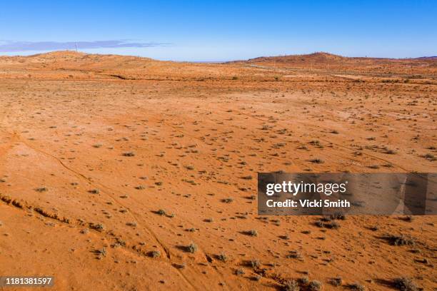 aerial view of dry barren countryside depicting drought conditions with a road and clear blue sky - terrain stock pictures, royalty-free photos & images