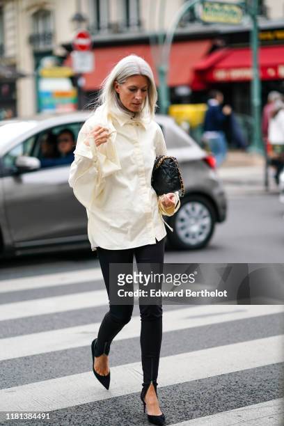 Sarah Harris wears a cream-color shirt, a black quilted bag, black skinny pants, black pointy heels, outside Ralph & Russo, during Paris Fashion Week...
