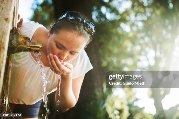 woman drinking water in rome from fountain. - drinking fountain stock pictures, royalty-free photos & images