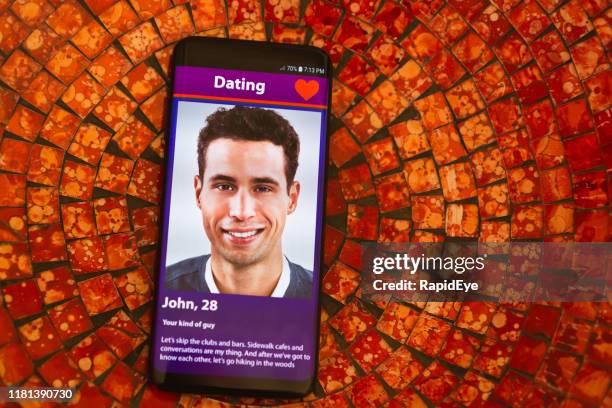 smiling young man on mobile phone dating app - dating app stock pictures, royalty-free photos & images