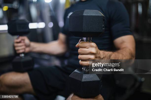 muskulöser mann bei gewichteten übungen - hand weight stock-fotos und bilder