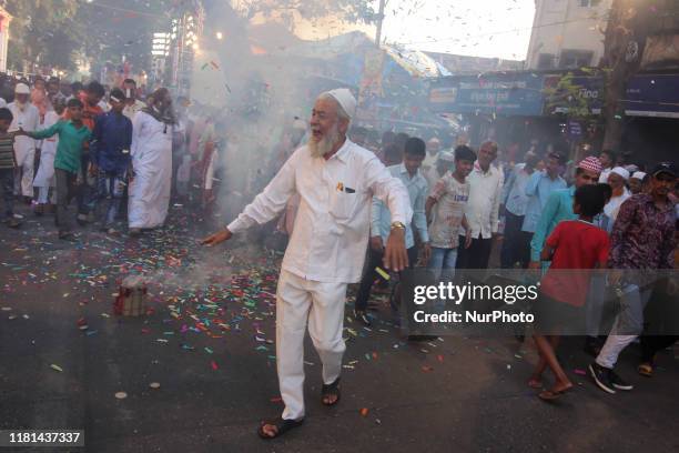 Man runs as firecrackers explode during a religious processions to celebrate Prophet Muhammad's birthday in Mumbai, India on 10 November 2019.