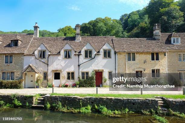 the beautiful houses in bibury village under the sunlight of the summertime in the uk - wiltshire imagens e fotografias de stock