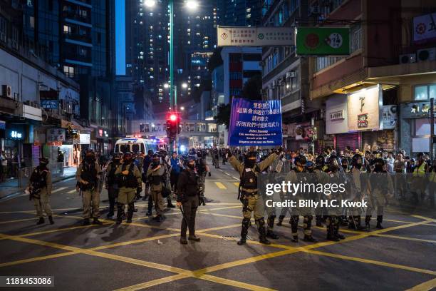 Riot police raise a blue flag as they secure an area in Tuen Mun district on November 10, 2019 in Hong Kong, China. Hong Kong slipped into a...