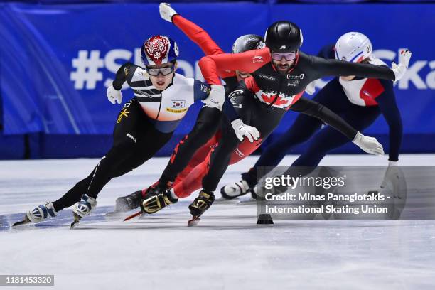 Charles Hamelin of Canada grabs a hold of Dong Wook Kim of SouthKorea in the men's 1000 m quarterfinals during the ISU World Cup Short Track at...